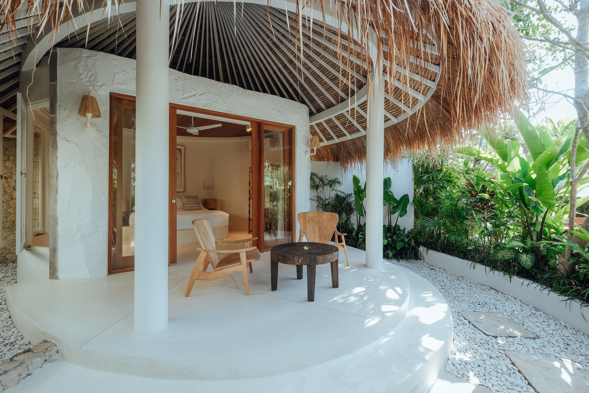 Villa terrace with thatched roof and tropical greenery